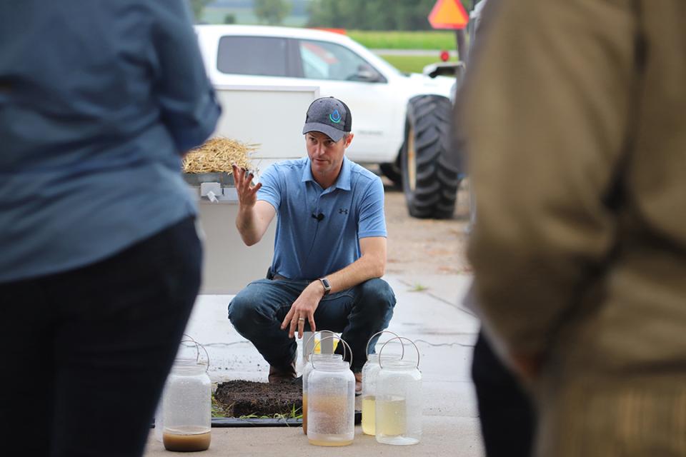 Aaron Hird demonstrates impact of rainfall on different systems using a rainfall simulator