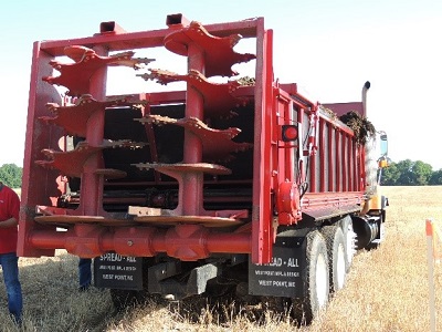 Vertical beaters on a solid manure spreader.