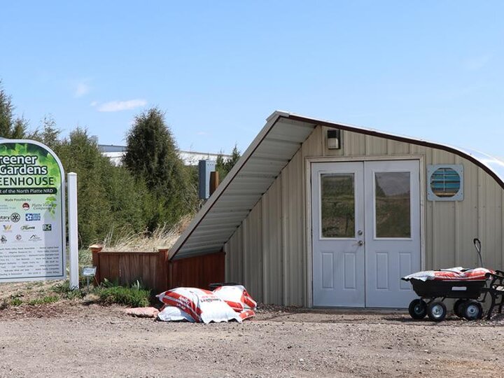 greenhouse with signage in foreground