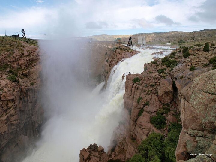 Water from Pathfinder Reservoir on the North Platte River near Casper, Wyoming, is sent over the overflow spillway. Water is spilled occasionally when snowmelt runoff from the mountains above Pathfinder becomes too great to store in the reservoir. (Photo credit: Gary Stone)