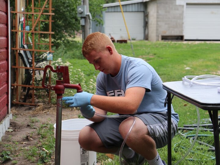 Student collecting water from a hydrant