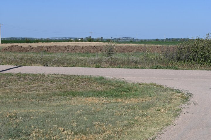 photo of stockpiled manure across the road from a driveway.