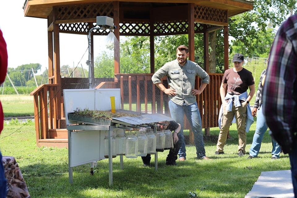 man stands near rainfall simulator during presentation