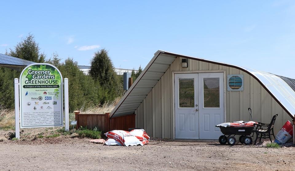 greenhouse with signage in foreground